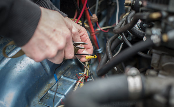 A person using a multi-tool attached to a 16-inch Key Strap with a split-ring o-ring.